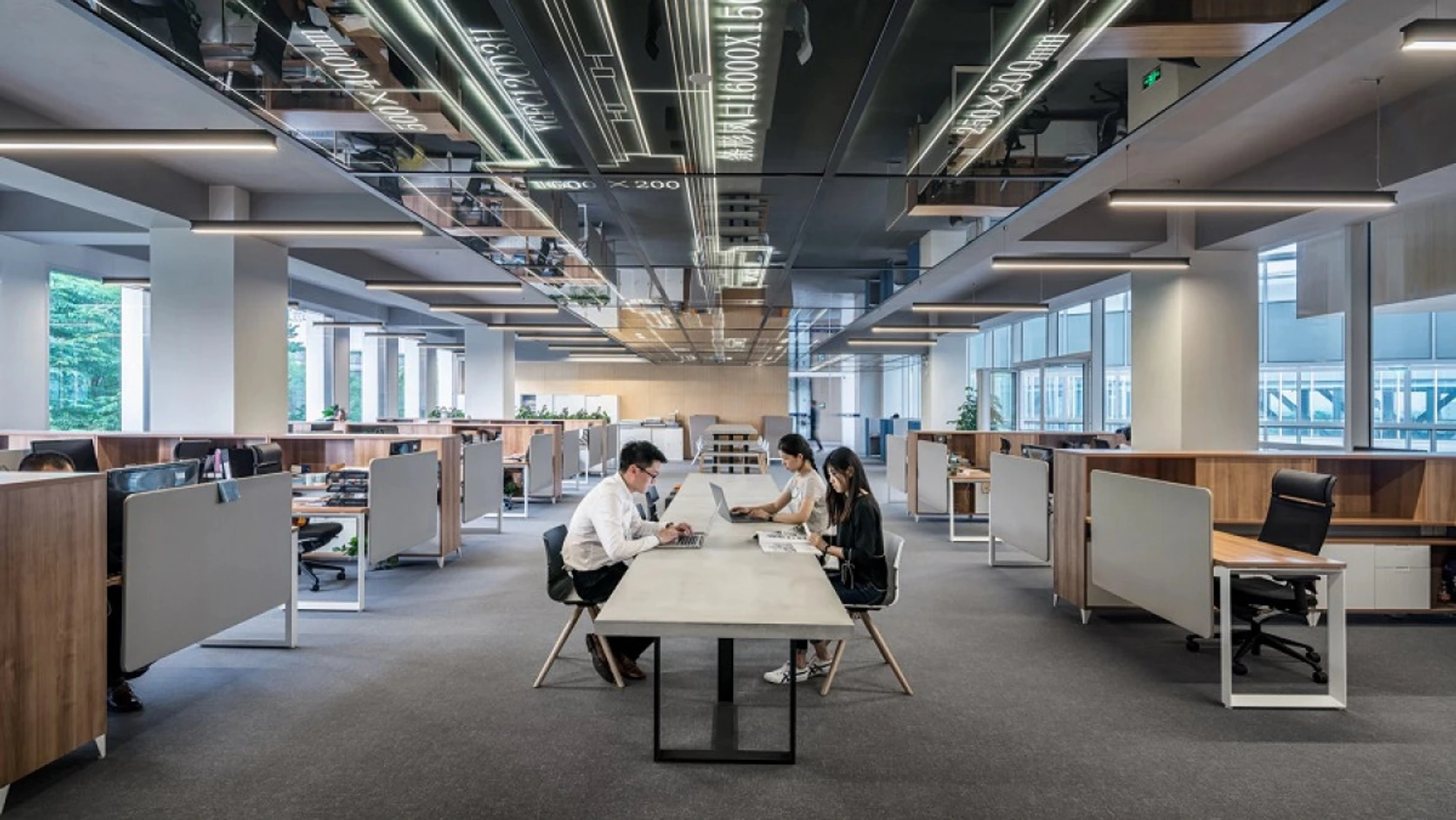 Oficina abierta con un equipo reunido alrededor de una mesa de trabajo